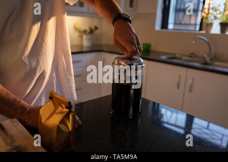 Mature man preparing coffee in kitchen at home Stock Photo