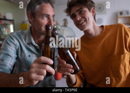 Father and son toasting beer bottle Stock Photo