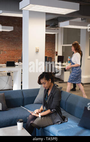 Businesswoman using digital tablet on sofa Stock Photo