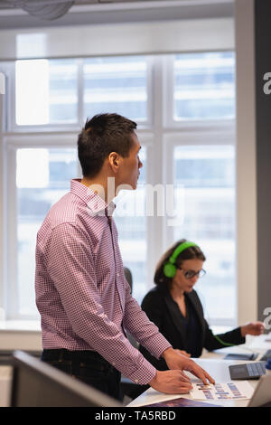 Thoughtful businessman standing in the office Stock Photo