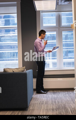 Businessman talking on mobile phone while looking at photograph Stock Photo