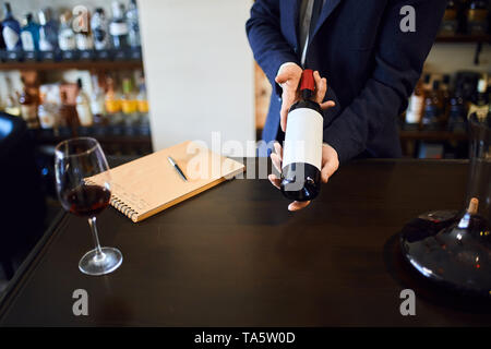 man in suit offer perfect wine for customers, clients. business. close up cropped photo. Stock Photo