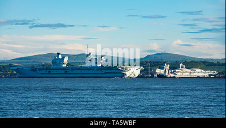 Rosyth, Scotland, UK. 22nd May, 2019. Aircraft carrier HMS Queen Elizabeth moored off Rosyth in the River Forth after leaving dry dock yesterday after a visit to her home port. She will leave the Forth today and return to sea in preparation for Westlant 19 deployment which is designed to focus on the operations of her F-35 fighter aircraft. Pictured; Rare view of both of the Royal Navy's aircraft carriers. HMS Queen Elizabeth on left and HMS Prince of Wales still under construction in shipyard at Rosyth. Credit: Iain Masterton/Alamy Live News Stock Photo