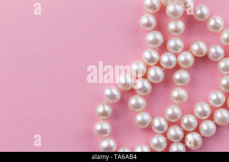 Pearl background with nacreous pearl necklace on pink background - close up macro photo Stock Photo