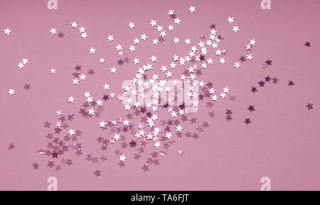 Festive background with silver star confetti on purple background. Flat lay for holiday, Christmas or party design. Stock Photo