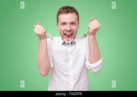 Hungry man holding fork and knife on hand to eat Stock Photo