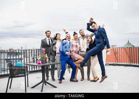 A group of joyful businesspeople having a party outdoors on roof terrace in city. Stock Photo