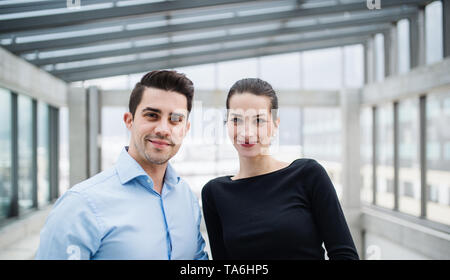 Two young architects standing in office, looking at camera. Stock Photo