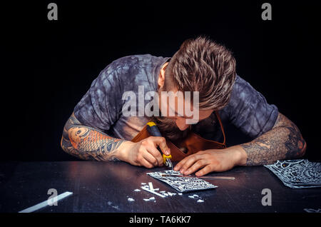 Artisan of leather processes a workpiece from leather  Stock Photo