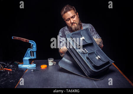 Leather Artist producing leather workpiece in workshop Stock Photo