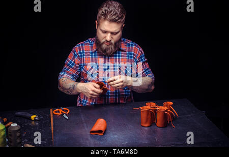 Leather Currier producing a leatherwork at his workshop Stock Photo