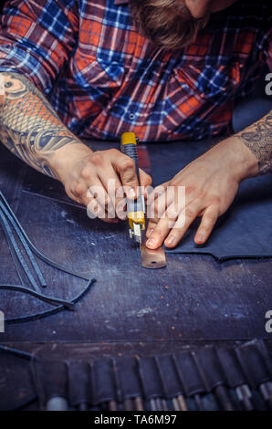 Artisan cutting out leather goods  Stock Photo