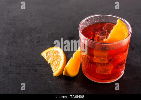 Negroni cocktail with piece of orange in glass on black background. Copyspace Stock Photo