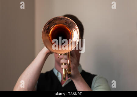 Trumpeter with trumpet in hands. It is a brass instrument commonly used in classical and jazz ensembles Stock Photo