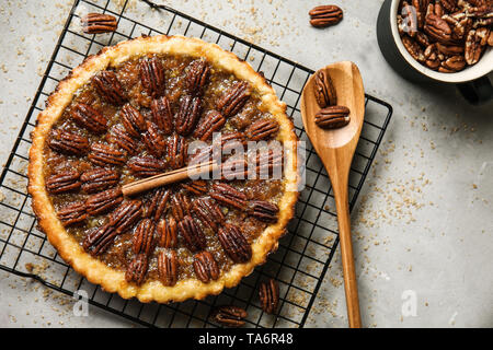 Cooling rack with tasty pecan pie on grey table Stock Photo