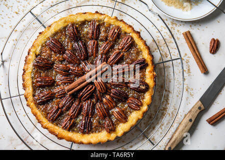 Cooling rack with tasty pecan pie on light table Stock Photo