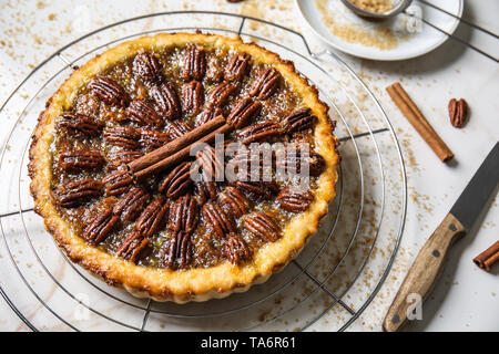 Cooling rack with tasty pecan pie on light table Stock Photo