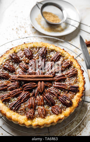 Cooling rack with tasty pecan pie on light table Stock Photo