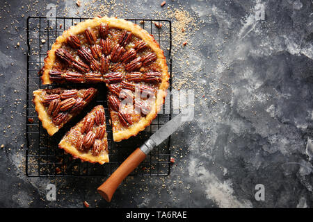 Cooling rack with tasty pecan pie on grey background Stock Photo