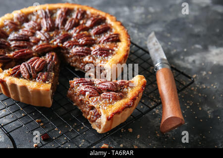 Cooling rack with tasty pecan pie on grey background Stock Photo