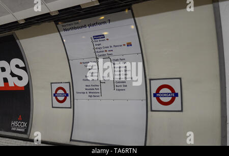 Metro stop in London, United Kingdom, June 14 2018. Among the informational signs the unmistakable red circular logo indicates the name of the station Stock Photo