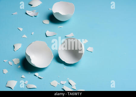 Cracked egg on light blue background. Text space Stock Photo