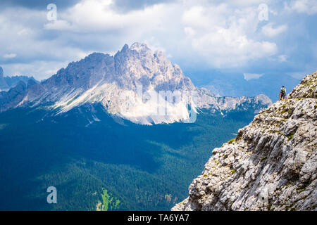 Dolomites mountains, Italy - August 20, 2018: Rock traverse with a view towards Monte Cristallo on a bright and hot Summer day. Panoramic views over g Stock Photo