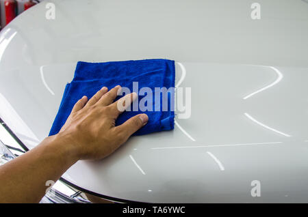 Hand man worker use clean blue cloth to wipe the car Stock Photo