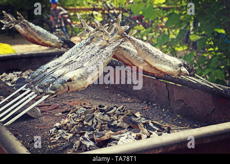 Mackerels grilled outside on the fire embers for a rustic party Stock Photo