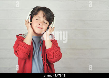 happy child in headphones against brick background Stock Photo