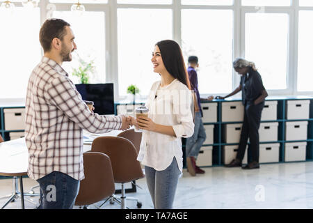 Smiling businesswoman shaking hand of colleague, greeting, getting acquainted with new employee during coffee break, smiling manager handshaking with  Stock Photo