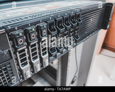 Close up of 2.5 inches hard drives bay in front of a working rack server installed in the server room to store information and data Stock Photo