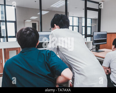 Thai Computer Engineering students working on a programming project in a computer lab Stock Photo