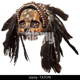 A Papua New Guinean ancestor's skull of the Asmat people Polychrome painted human skull without lower jaw, the eye sockets filled with seeds. Nose with elaborate nose plug. Textile headdress with shells and feathers. Height 15 cm. historic, historical, Indonesian archipelago, Indonesia, Far East, Asia, Asian, ethnology, ethnicity, ethnic, tribal, object, objects, stills, clipping, clippings, cut out, cut-out, cut-outs, Additional-Rights-Clearance-Info-Not-Available Stock Photo