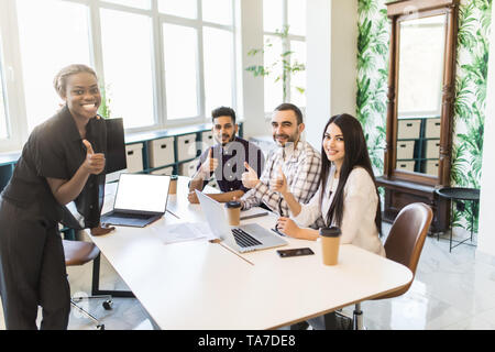 Black female boss leading corporate multiracial team meeting talking to diverse businesspeople, african american woman executive discussing project pl Stock Photo