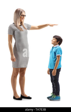 Full length shot of a woman gesturing with hand and showing the height of a young boy isolated on white background Stock Photo