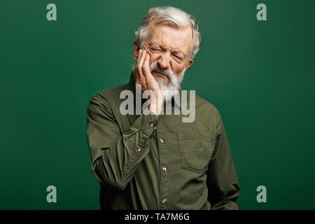 unhappy senior man with closed eyes holding cheek, man suffers from toothache, senior man problems with teeth. tooth care. health concept , isolated g Stock Photo