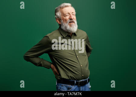week sick old man cannot stand stright, poor man suffering from radiculitis. close up photo. studio shot. Stock Photo
