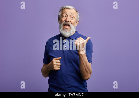funny friendly kind man showing to the side. close up portrait. studio shot. Stock Photo