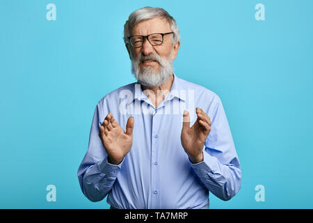 angry frustrated man wearing blue shirt expresses negative, aggressive expression.close up photo.isolated light blue background. Stock Photo