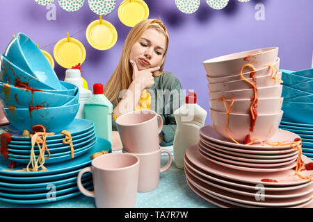 frowning housewife thinking idea and holding chin in the kitchen room, close up photo Stock Photo