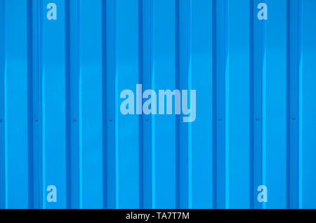Close up photo of a facade from an industrial building with graphic stripes of minimalistic vertical blue metal profiles. Background image. Stock Photo