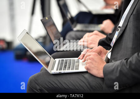 Detail with journalists hands typing on laptops during a press conference Stock Photo