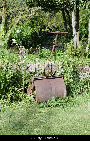 Cast iron grass lawn roller with feature handle in English garden Stock Photo