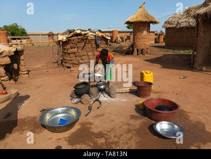 African woman preparing food in the house courtyard, Savanes district, Niofoin, Ivory Coast Stock Photo