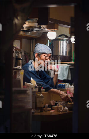 Osaka - November 02 2018: Staff in a small Izakaya restaurant (a traditional japanese pub for after-work drinking). Osaka, Japan Stock Photo