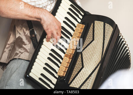 Accordionist plays vintage accordion. Close-up photo with soft selective focus Stock Photo