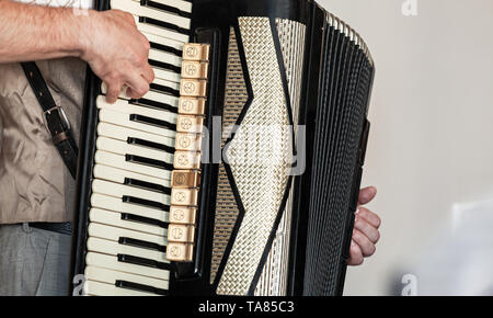 Accordionist plays vintage accordion. Close-up black and white photo with soft selective focus Stock Photo