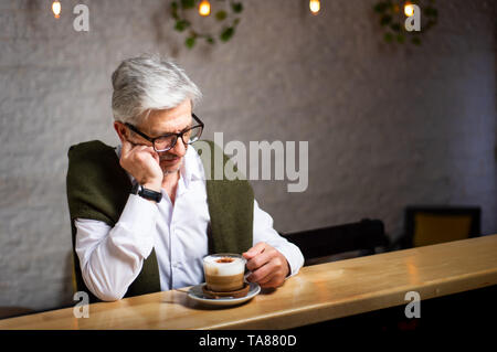 Pensive senior man having a coffee in the bar Stock Photo