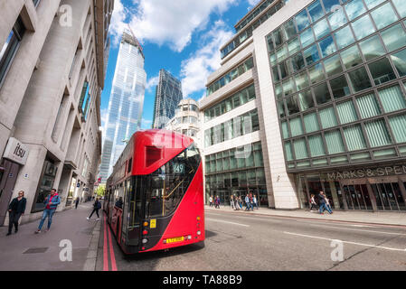 London, England - May 12, 2019: London's iconic red double-decker bus with awesome modern skyscrapers architecture in City . Stock Photo